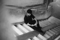 Pensive Young Adult Seated on Urban Staircase