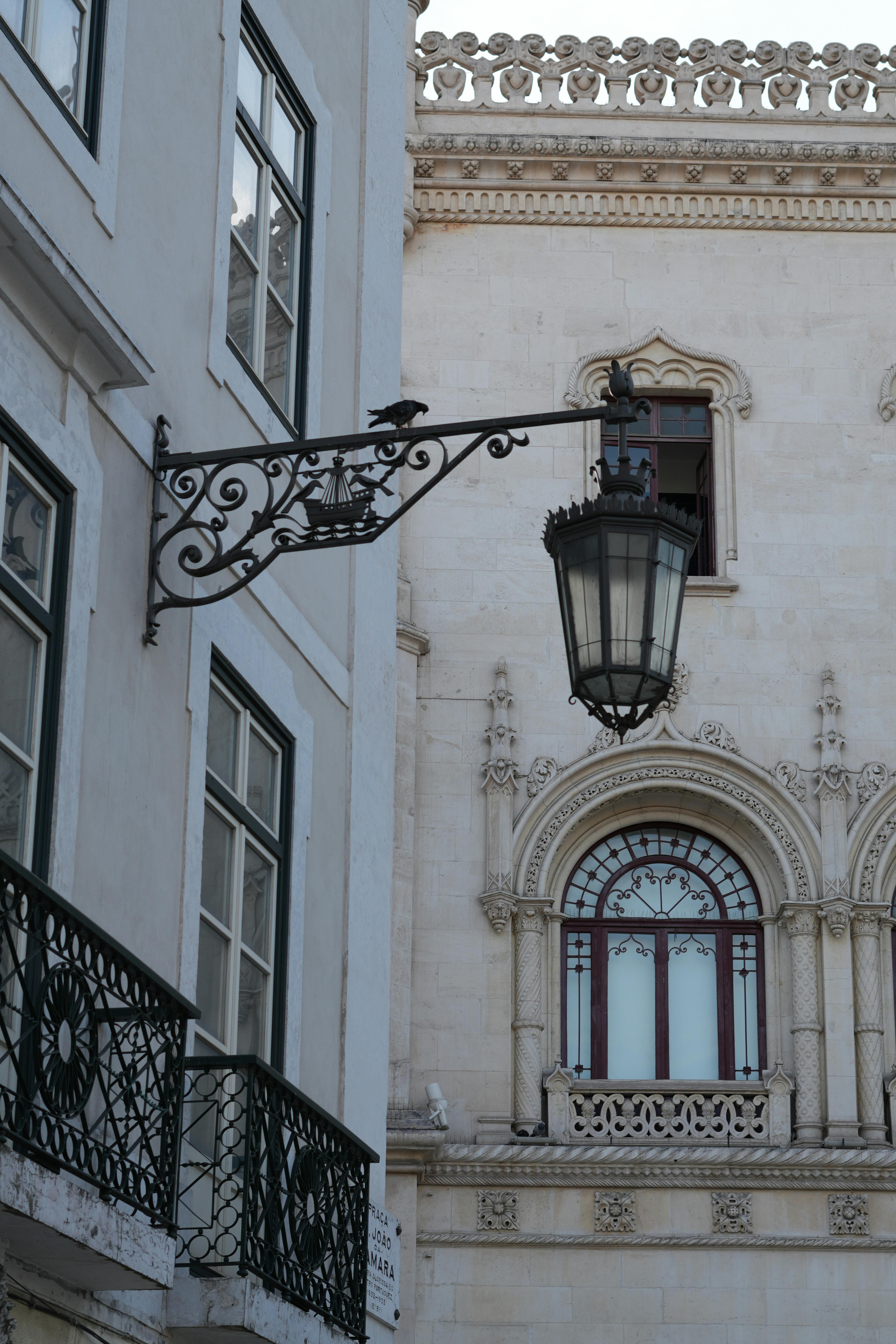 Gratis En vintage gadelampe mod en baggrund af udsmykket Lissabon-arkitektur. Lagerfoto