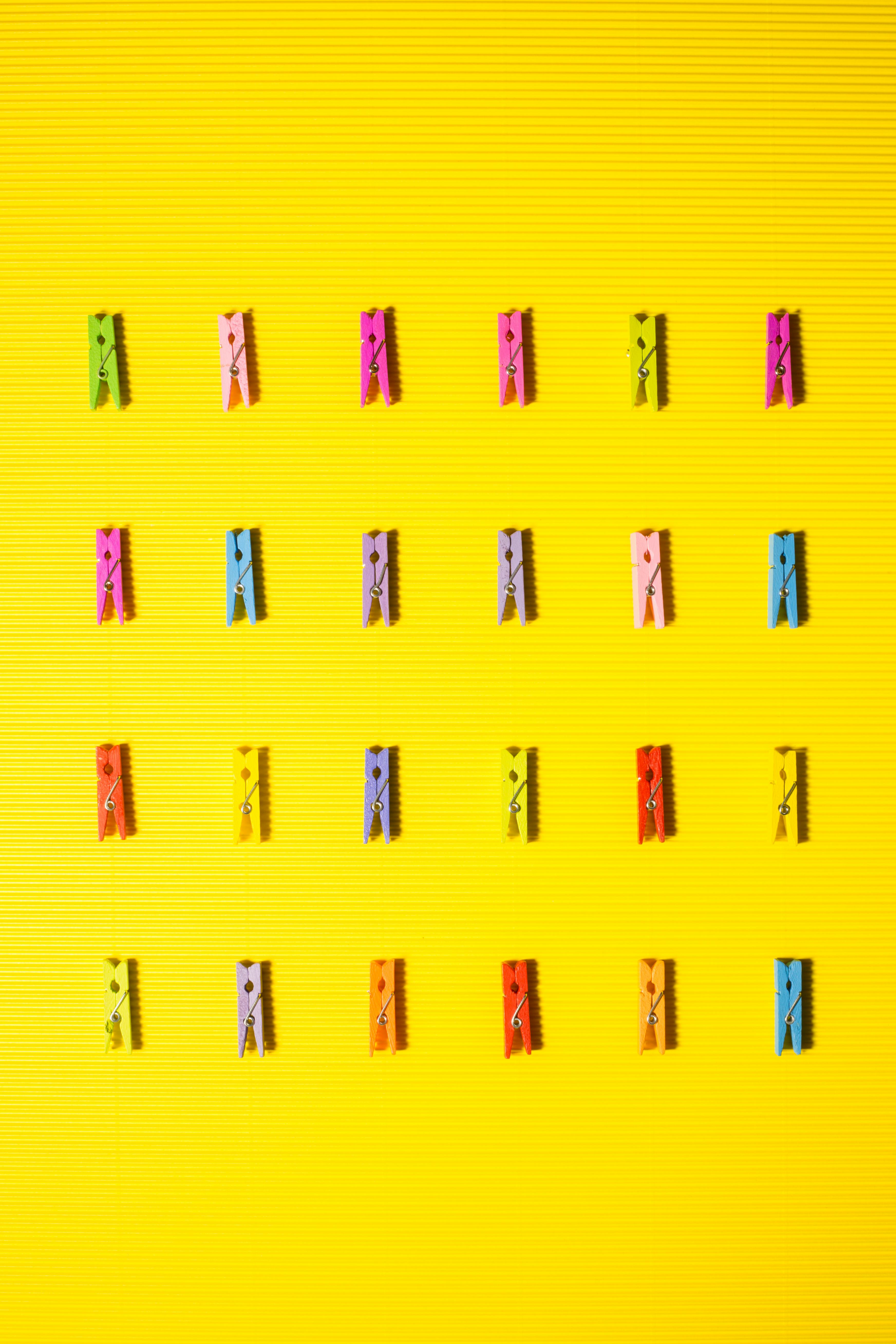 Gratis Una vivace disposizione di mollette colorate su una superficie gialla brillante per idee creative. Foto a disposizione