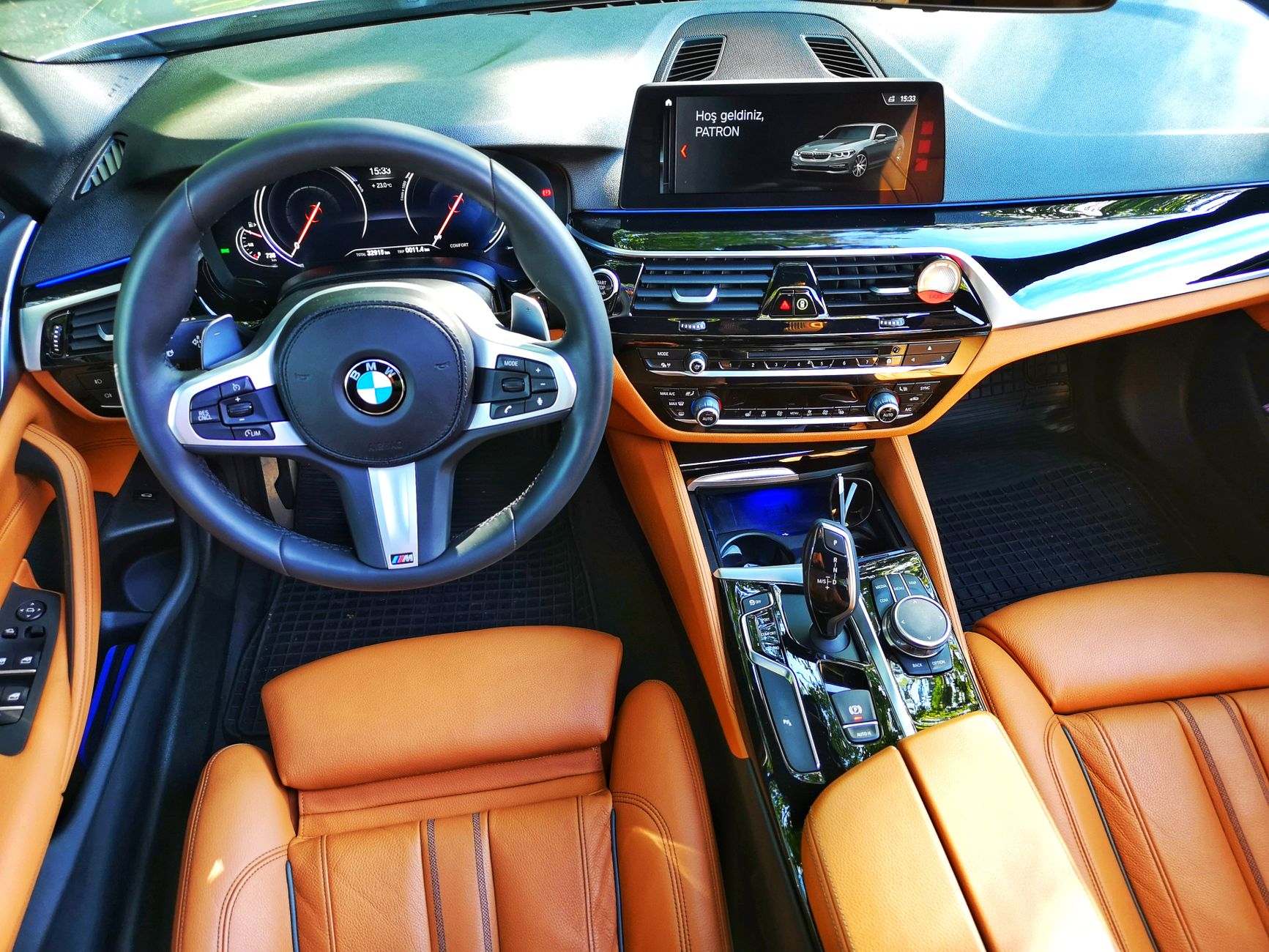 High-end car interior featuring tan leather seats, modern dashboard, and steering wheel.