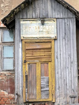 Rustic textured wooden door on an aged, weathered building exterior.
