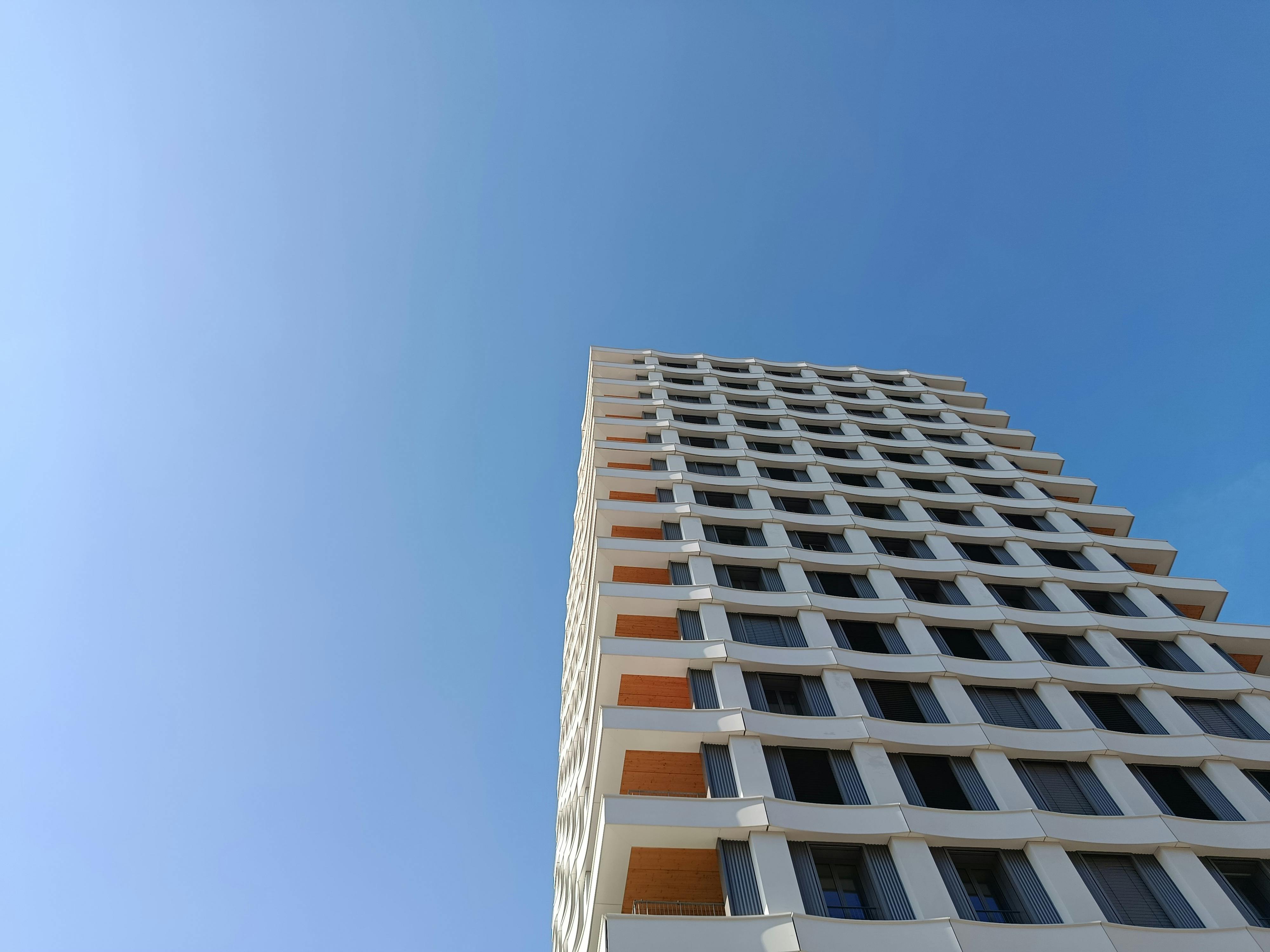 Gratis Udsigt opad af en højhus mod en klar blå himmel, der fremviser moderne arkitektur. Lagerfoto