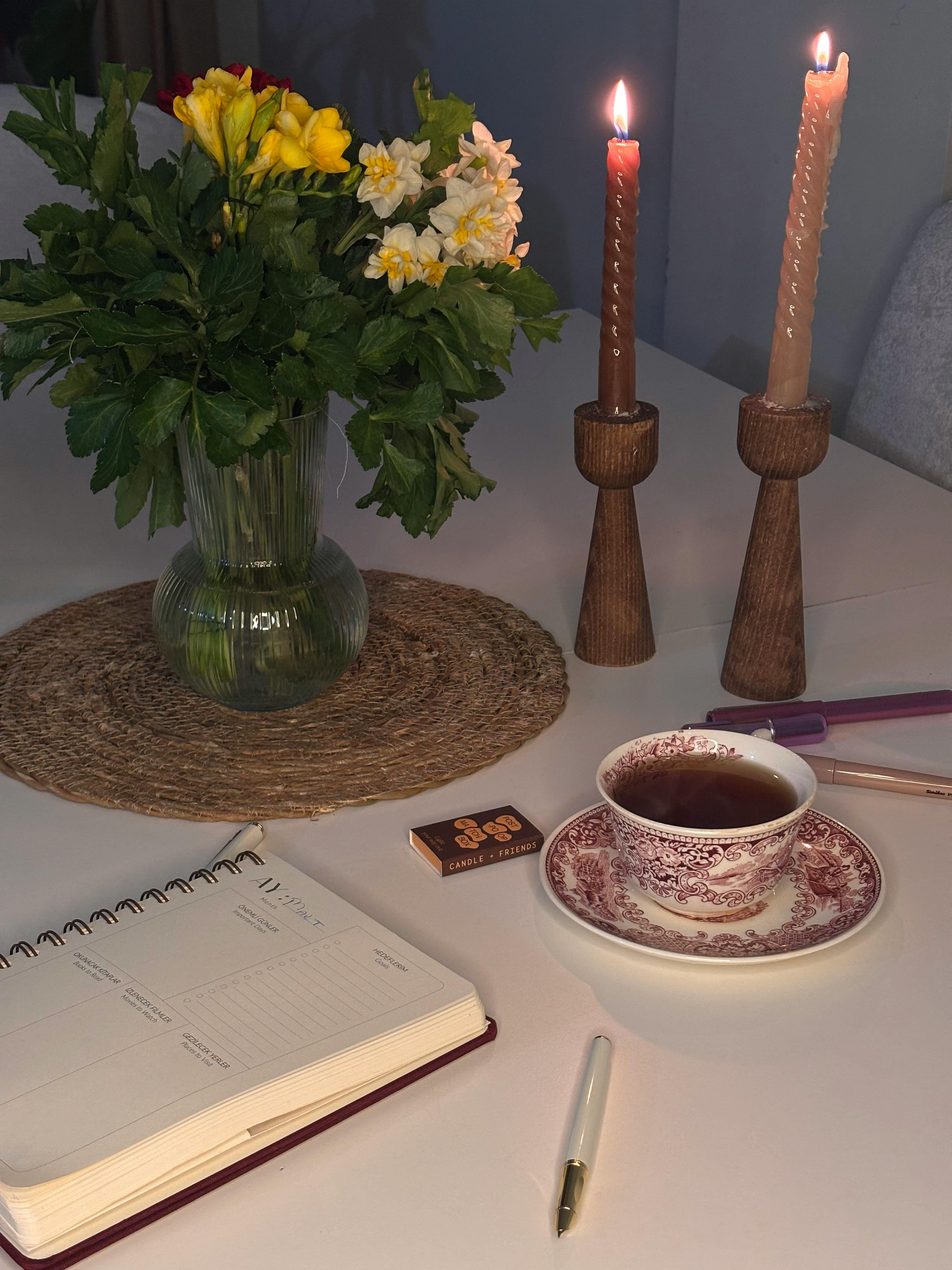 Free A serene tabletop scene with flowers, candles, and tea, perfect for relaxation. Stock Photo