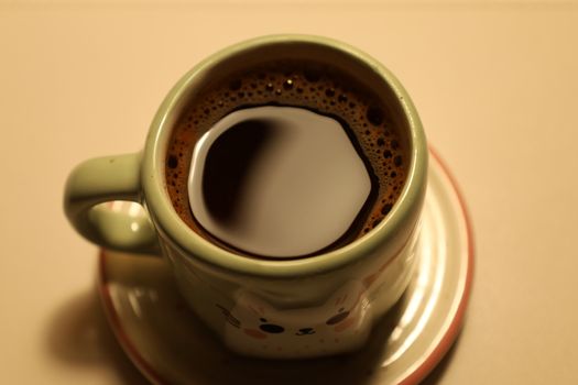Close-up of a freshly brewed coffee in a charming animal-themed mug.