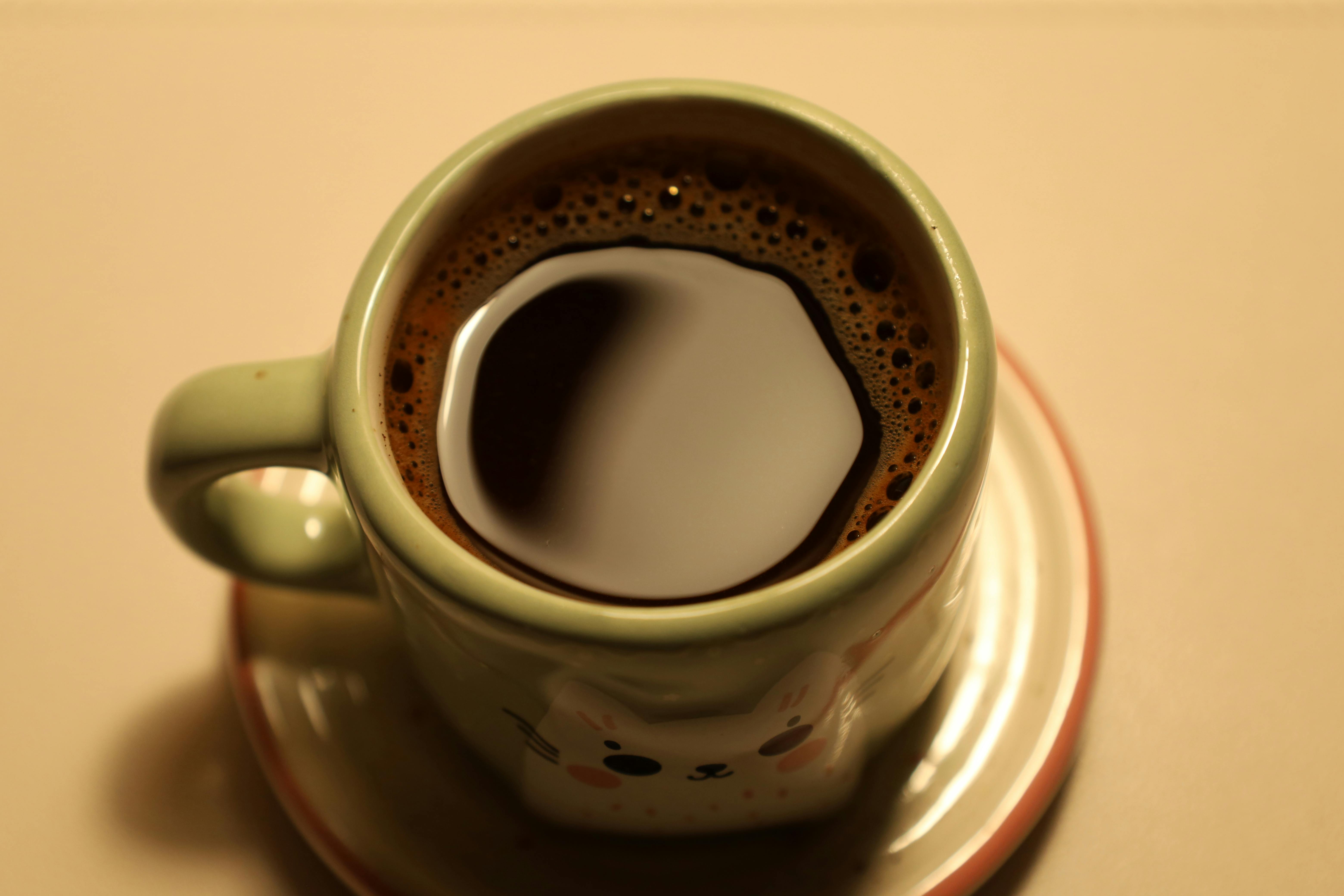 Free Close-up of a freshly brewed coffee in a charming animal-themed mug. Stock Photo