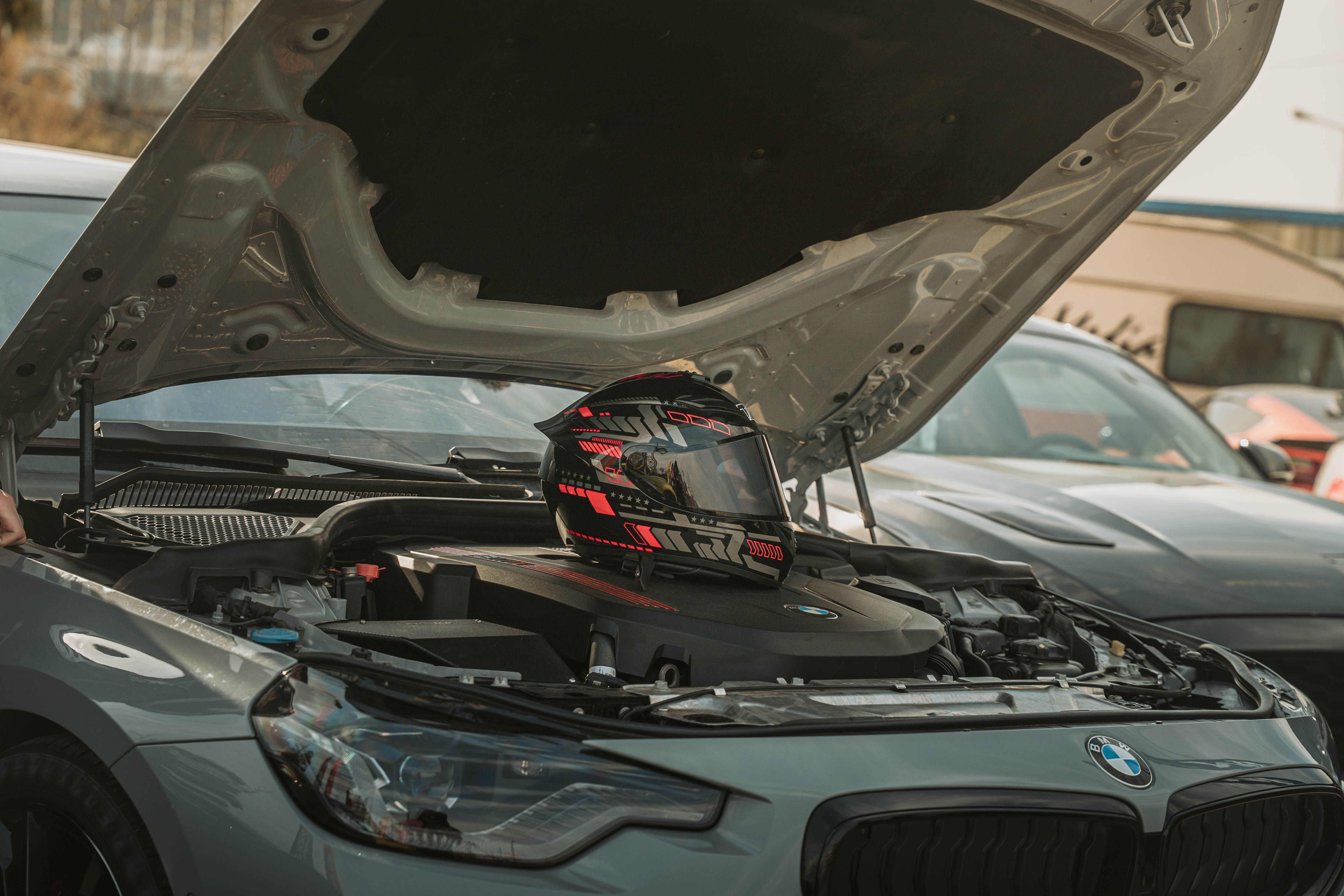 Open Car Hood with Racing Helmet on Engine · Free Stock Photo