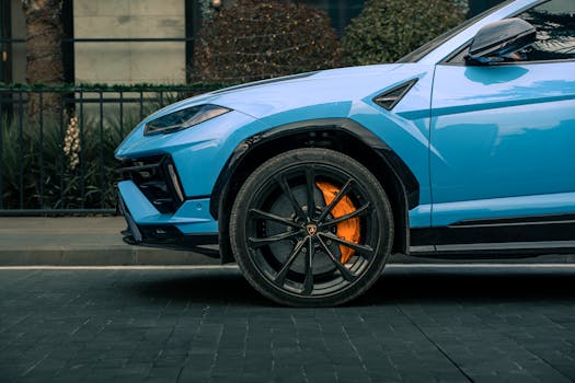Close-up of a blue luxury SUV on a city street in Erbil, Iraq, showcasing its design and wheel detail.