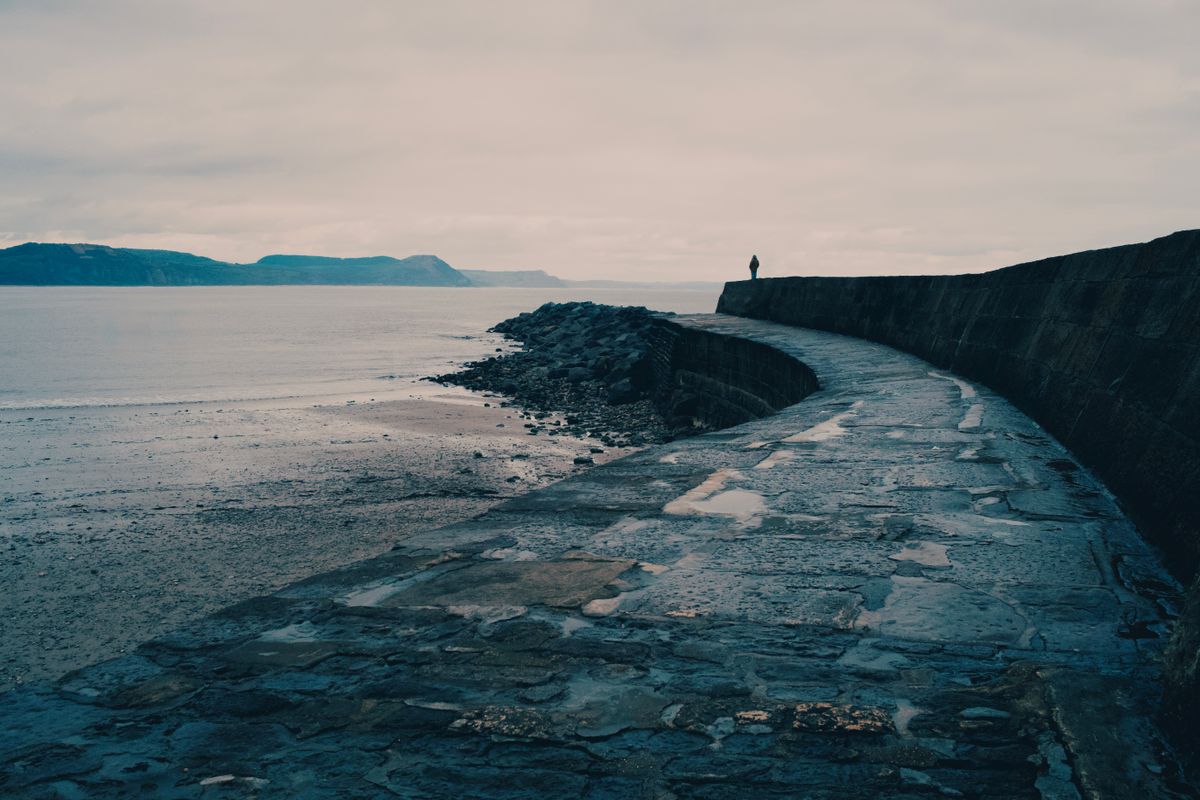 The historic Cobb harbour wall at Lyme Regis on an overcast day, photo by Ian on Pexels