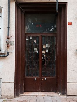 Front view of a classic brown door with intricate metal gate in an urban setting, perfect for architectural themes. — photo by Memet Öz