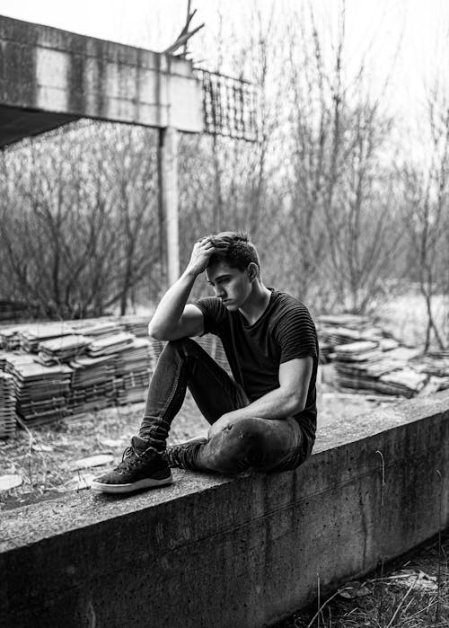 Homme Assis Sur Un Banc En Béton