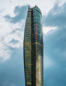 A modern skyscraper in Kuwait City reaching into the cloudy sky, showcasing contemporary architecture.