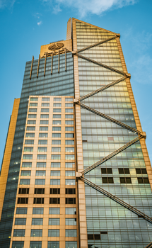 A towering modern skyscraper in Kuwait City, showcasing contemporary architecture against a blue sky.