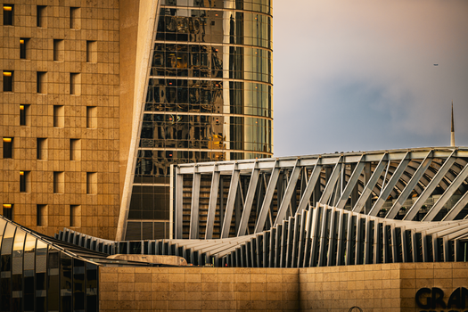 A striking view of modern architecture in Kuwait City during sunset, showcasing intricate designs.