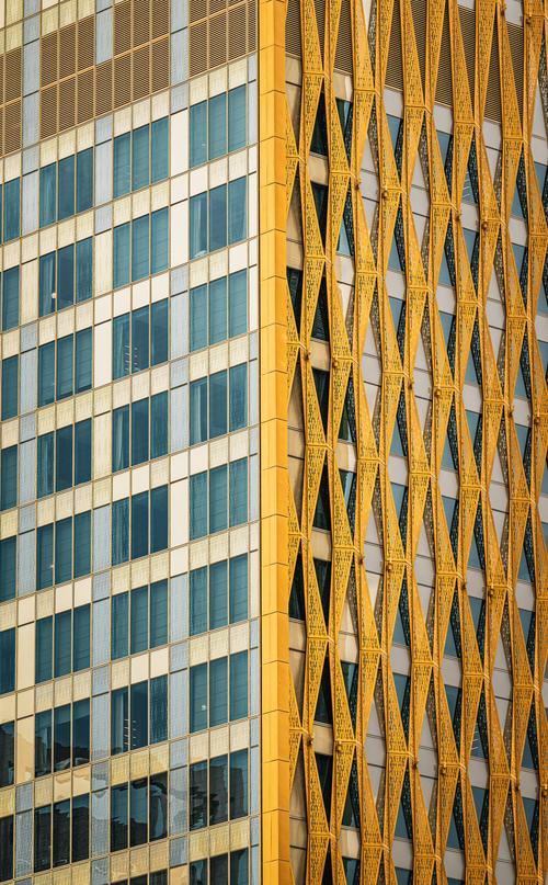 Free Dynamic architectural detail of a high-rise building's facade in Kuwait City with a gold lattice design. Stock Photo