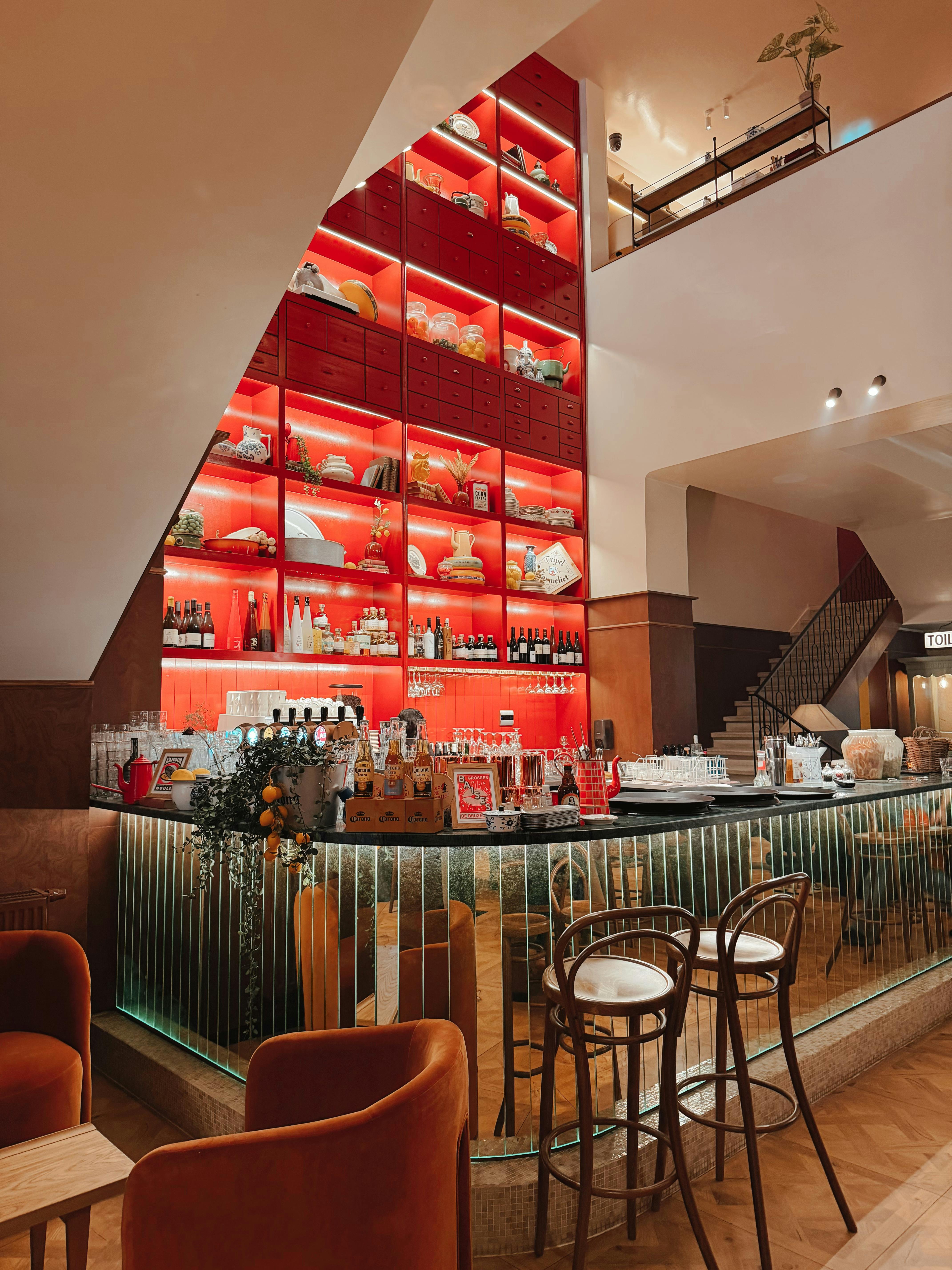 無料 印象的な赤い棚とスタイリッシュな座席を備えた現代的な屋内コーヒーショップのインテリア。 写真素材