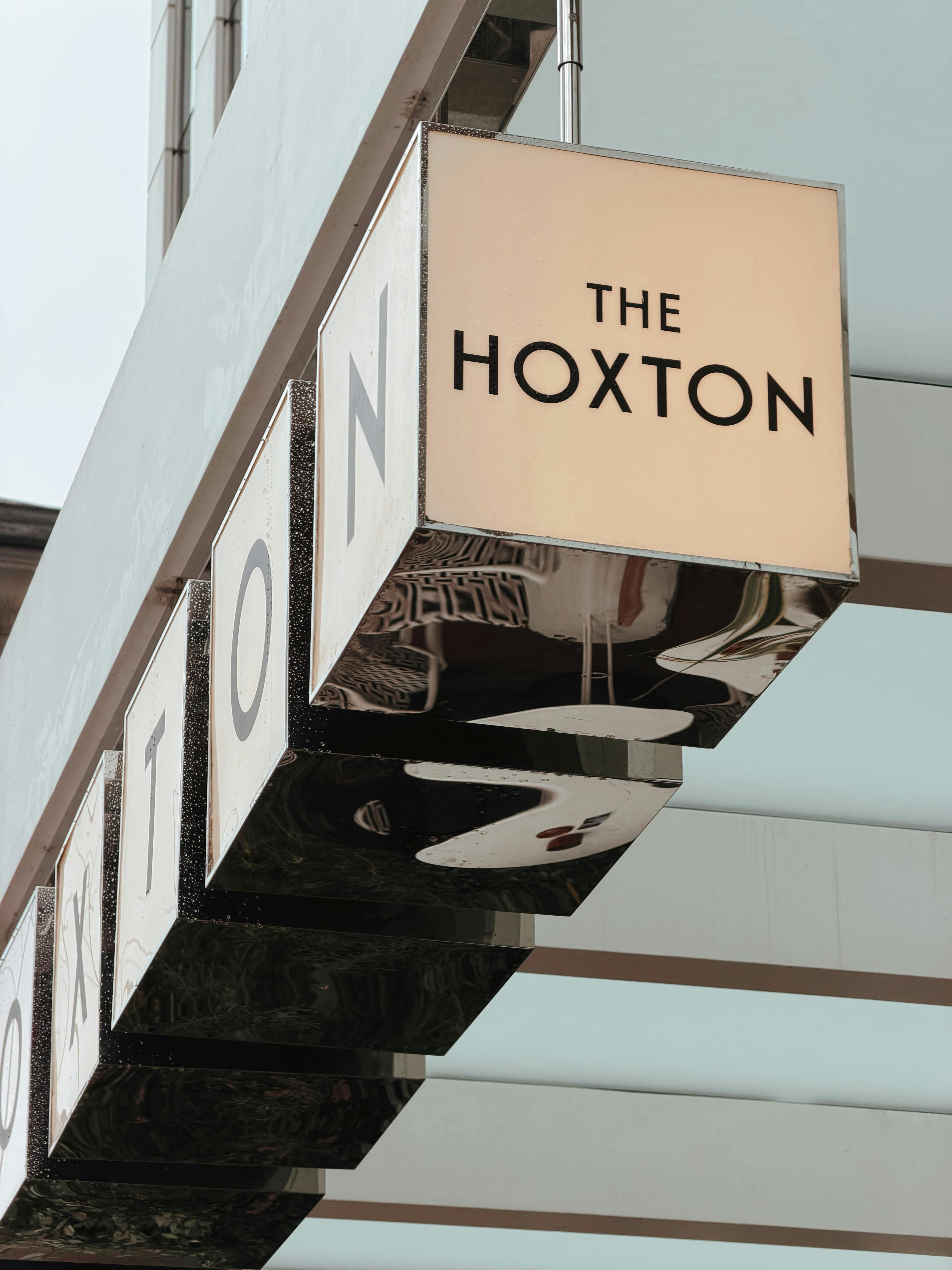 Gratis Papan nama elegan untuk The Hoxton Hotel dengan desain modern, ideal untuk tema perjalanan dan arsitektur. Foto Stok