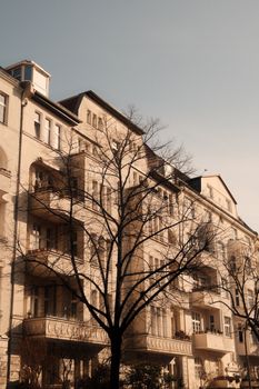Elegant Berlin building facade with bare trees in winter sunlight, showcasing classic architecture.