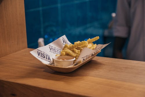 Brown and White Box With Fries on Brown Wooden Table