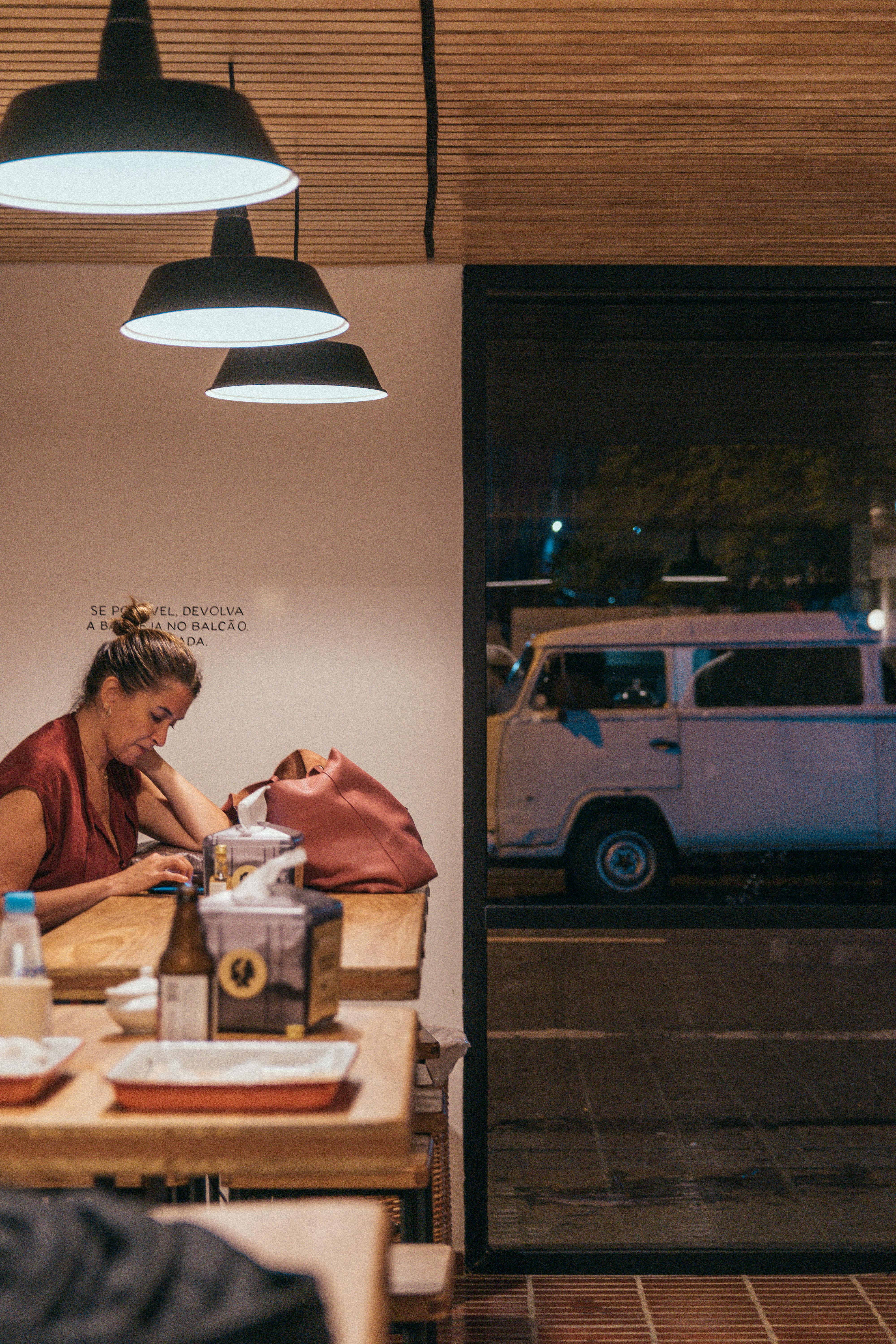 一位女士独自坐在圣保罗咖啡馆的乡村木桌旁用餐，营造出一种轻松的城市氛围
