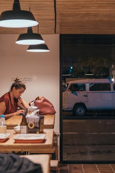 一位女士独自坐在圣保罗咖啡馆的乡村木桌旁用餐，营造出一种轻松的城市氛围