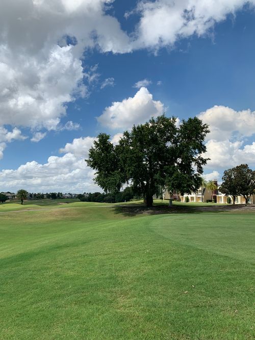 Free Scenic view of a golf course in Kissimmee, Florida under a blue sky with clouds. Stock Photo