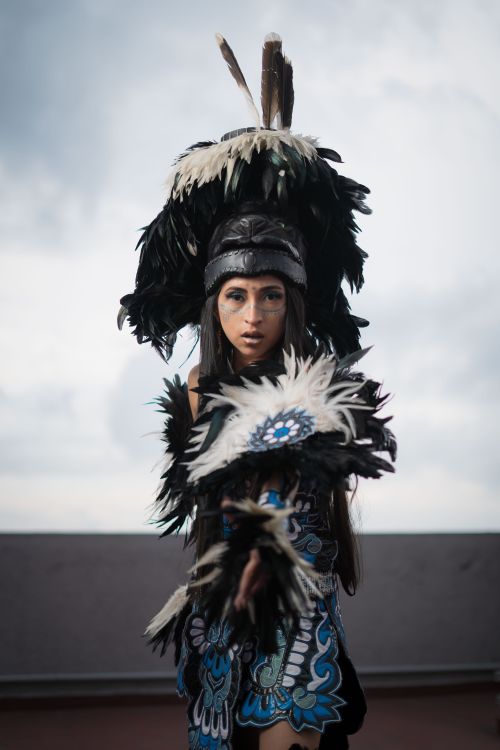 Free Woman in elaborate feathered headdress and costume, showcasing cultural heritage. Stock Photo