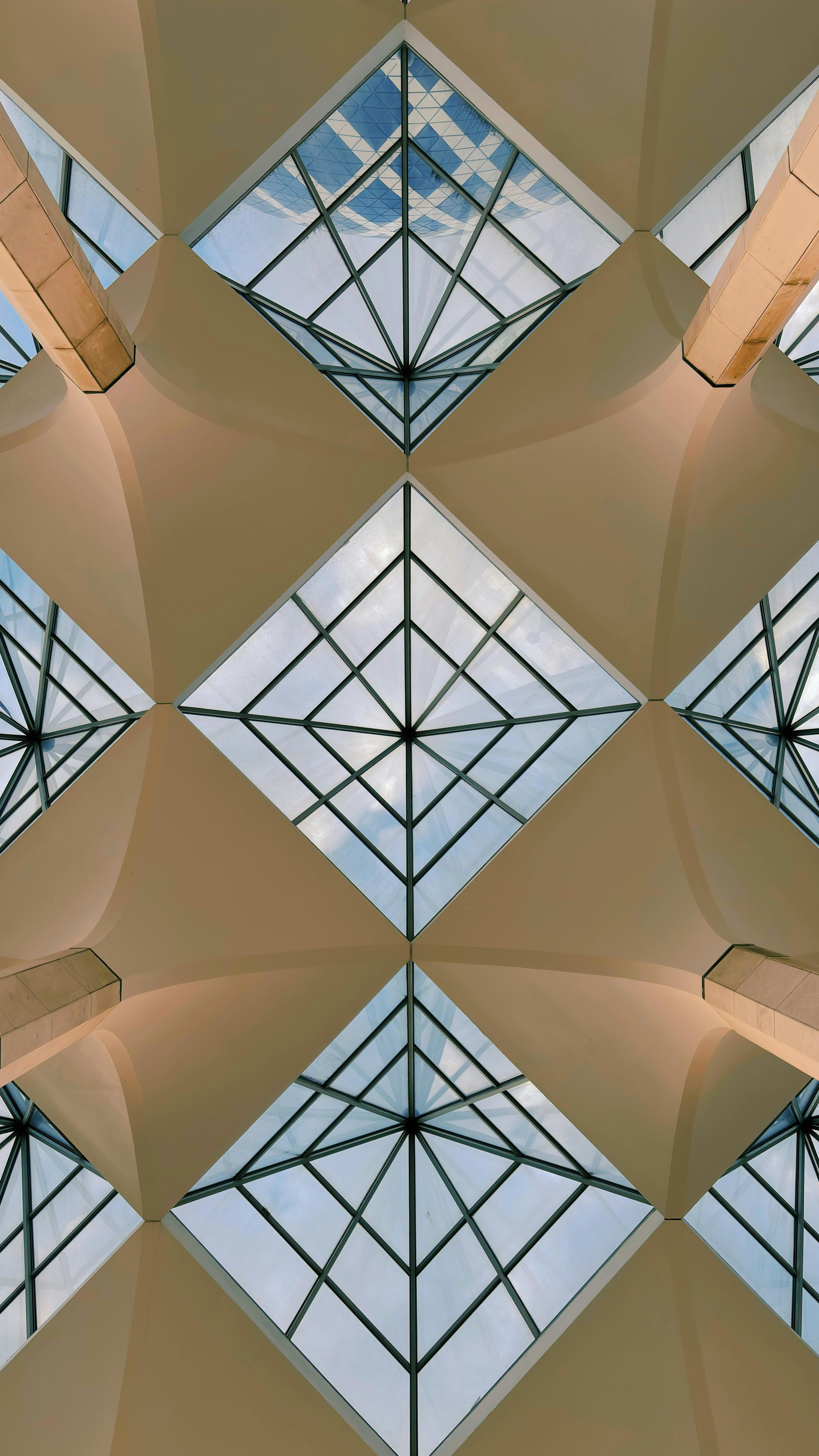 бесплатная Абстрактное изображение геометрического стеклянного потолка в Шах-Аламе, подчеркивающее современный архитектурный дизайн. Стоковое фото