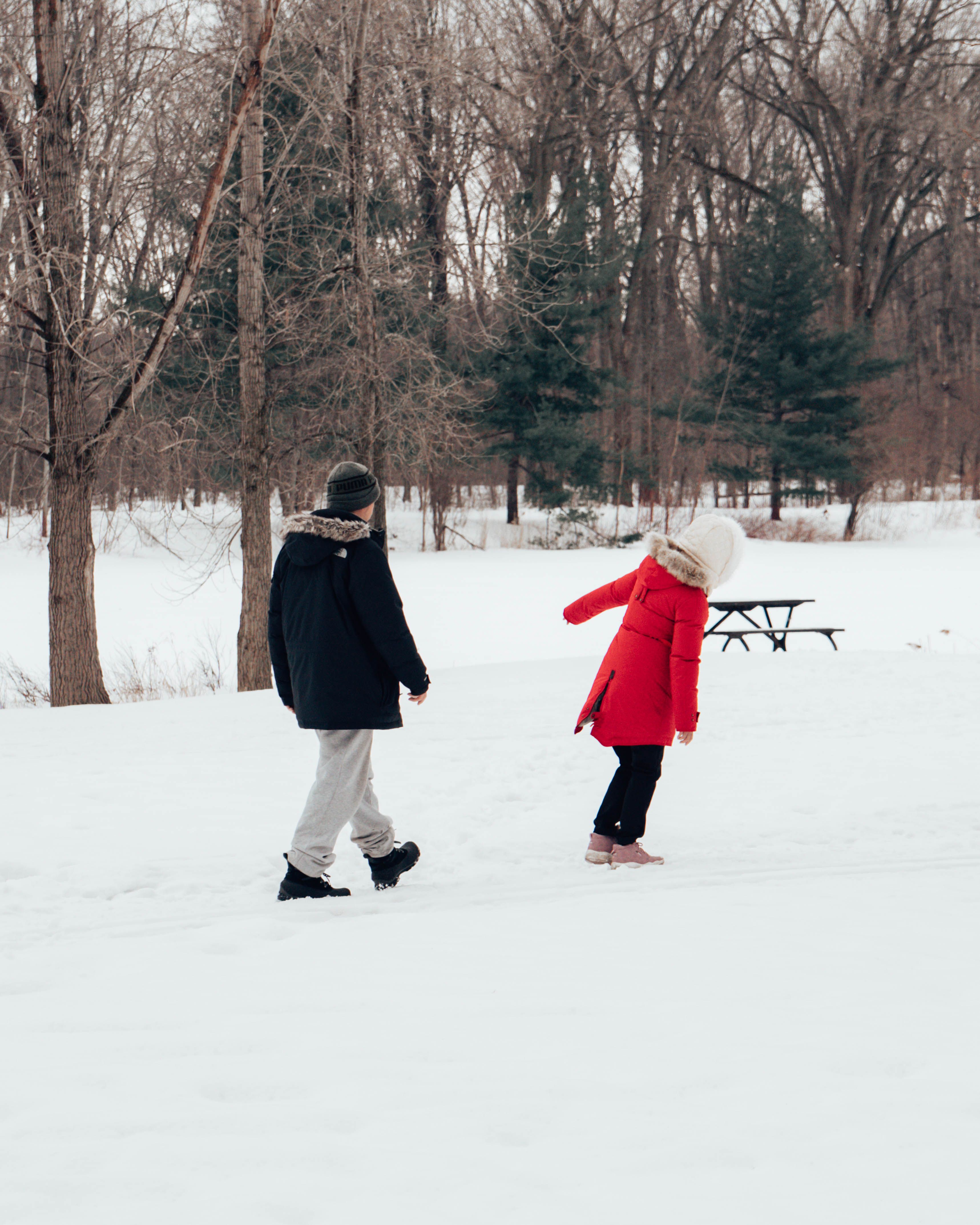 Two individuals enjoy a winter walk in a snowy park in Montréal, Canada.