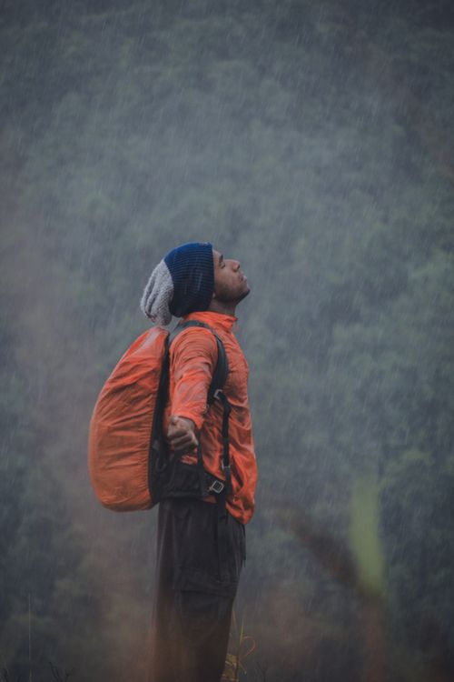 Free A solo hiker embraces the rain in the lush Highlands of Papua, Indonesia. Stock Photo
