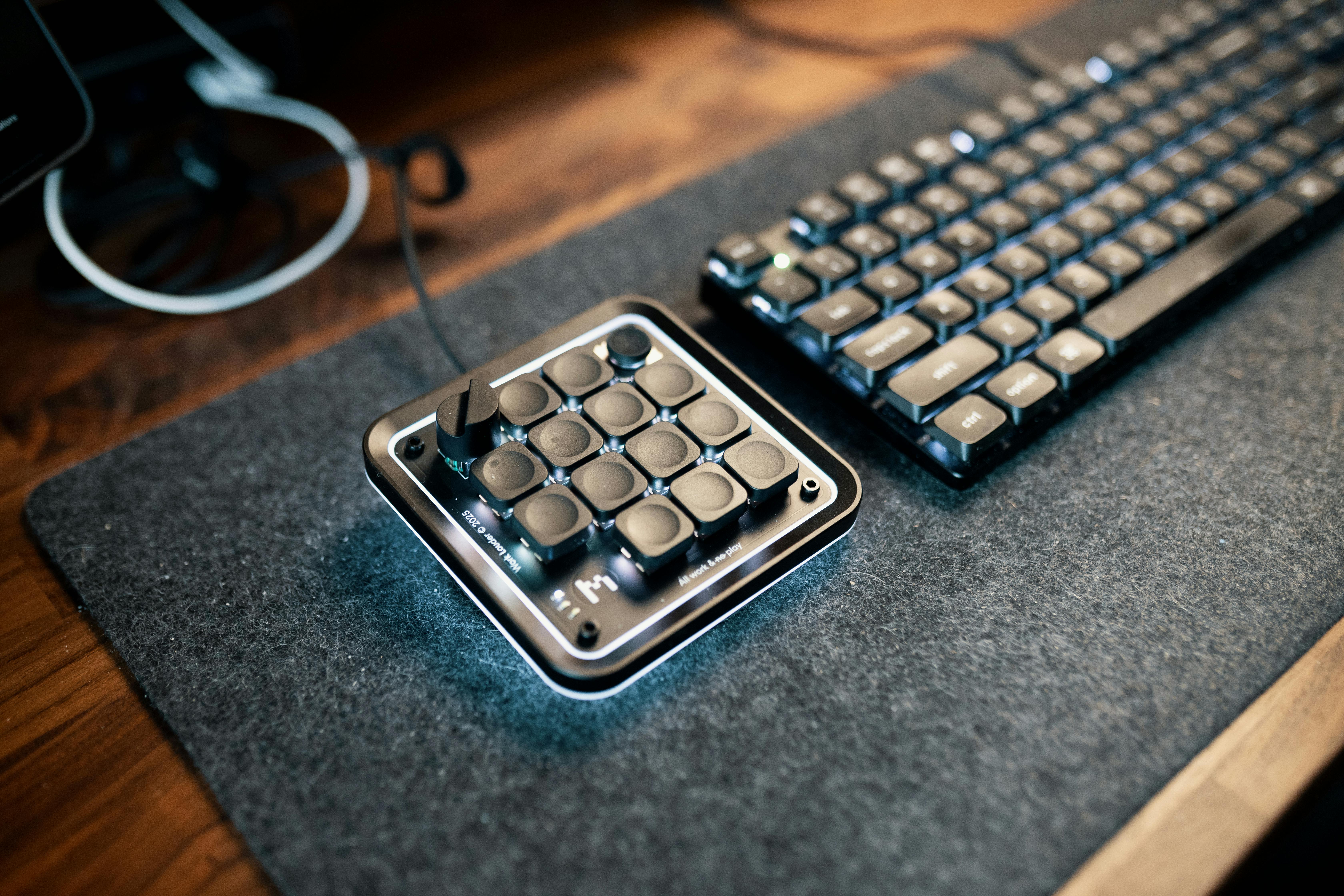 Gratis Un escritorio minimalista que cuenta con un teclado macro y un teclado mecánico para una computación eficiente. Foto de stock