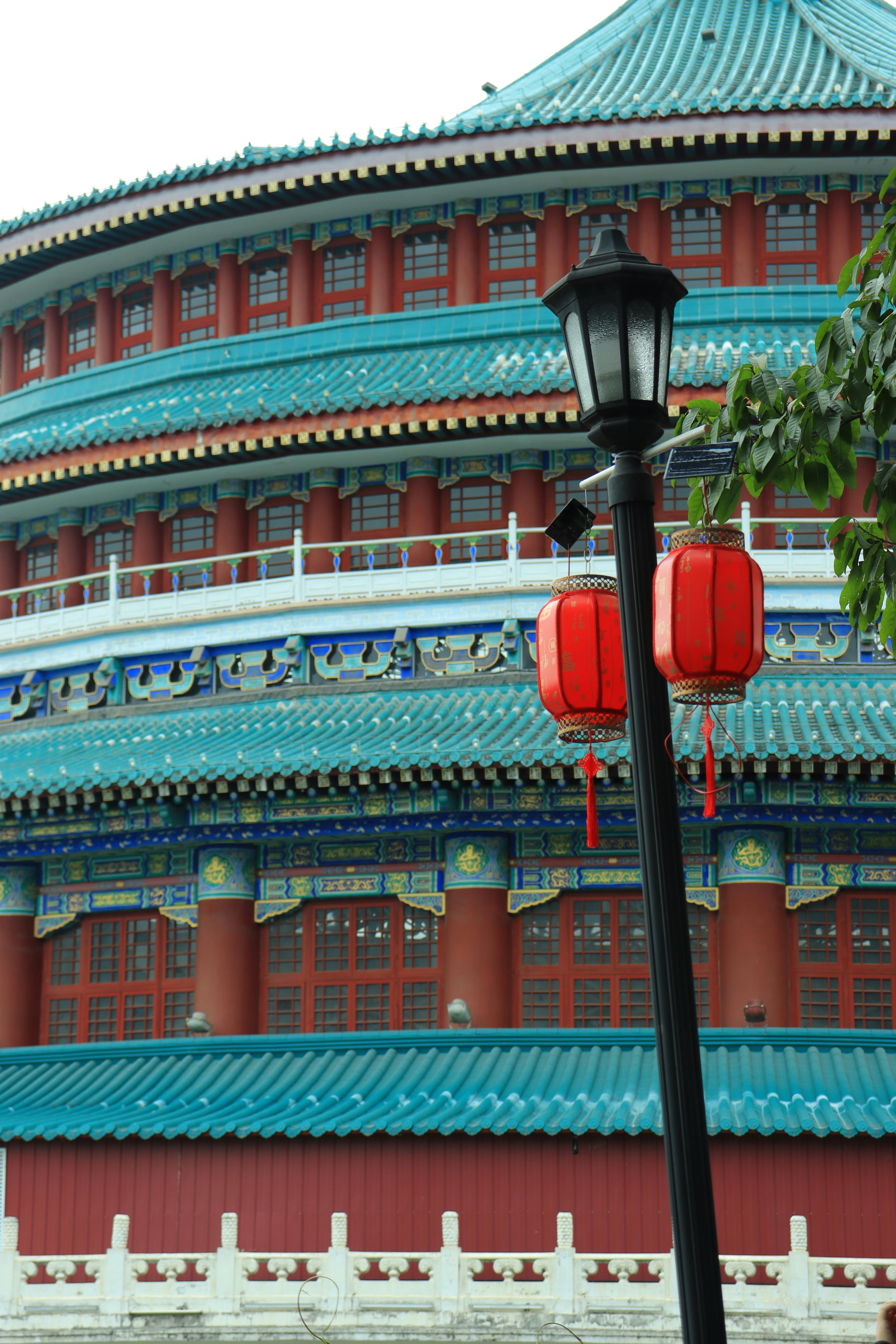 бесплатная Яркое китайское здание с фонарями в Чунцине днем, демонстрирующее традиционную архитектуру. Стоковое фото