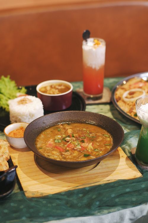 Free Savor authentic Indonesian dishes featuring spicy curry, rice, and refreshing beverages, perfect for a culinary adventure. Stock Photo