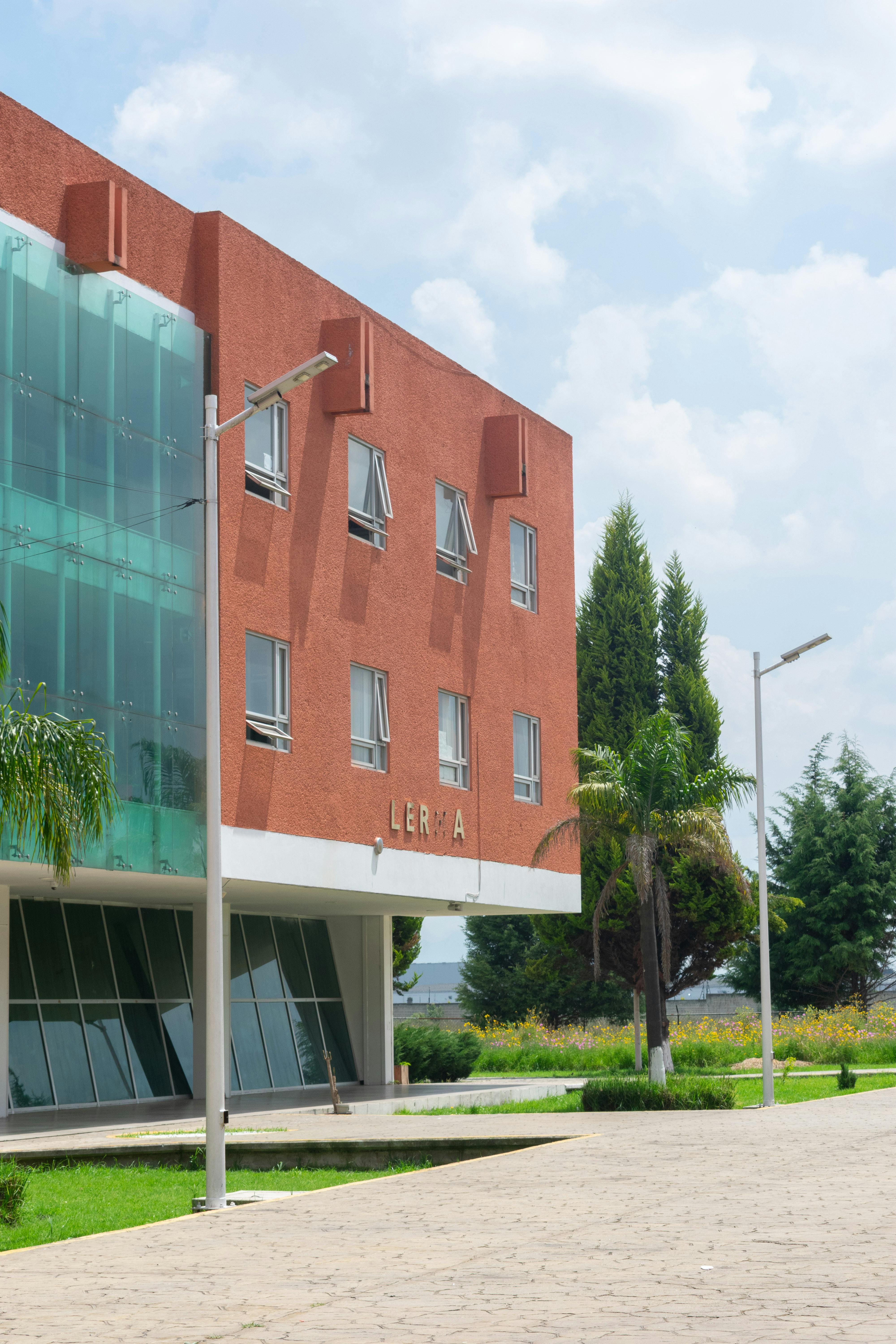 無料 レルマ デ ビジャダの明るい近代建築。緑豊かな背景に鮮やかな赤い建物が映えます。 写真素材