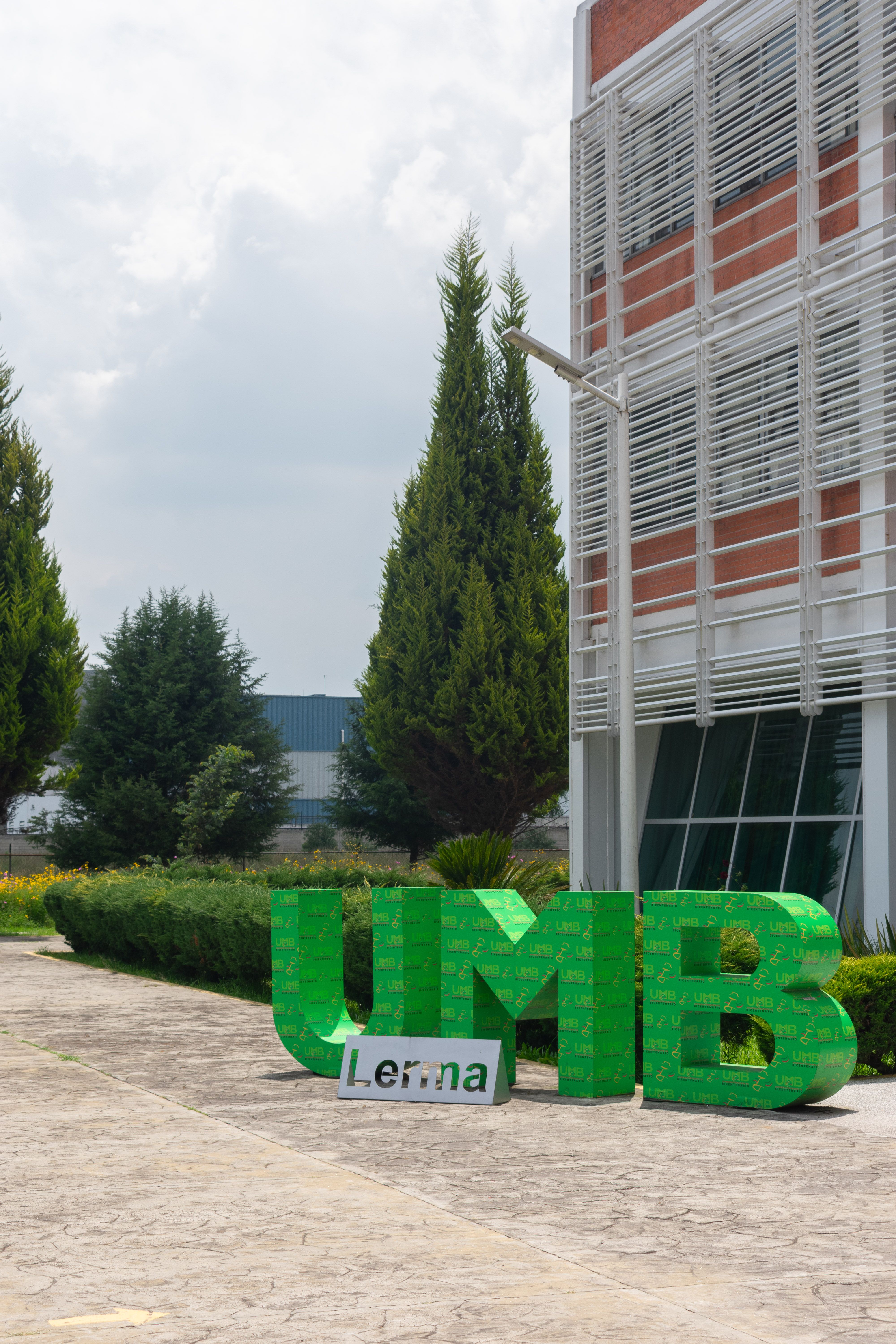 Contemporary architecture at UMB Lerma with lush greenery and clear sky.