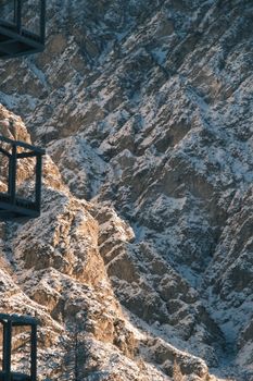 Dramatic view of snow-covered rocky mountains with balconies in foreground.