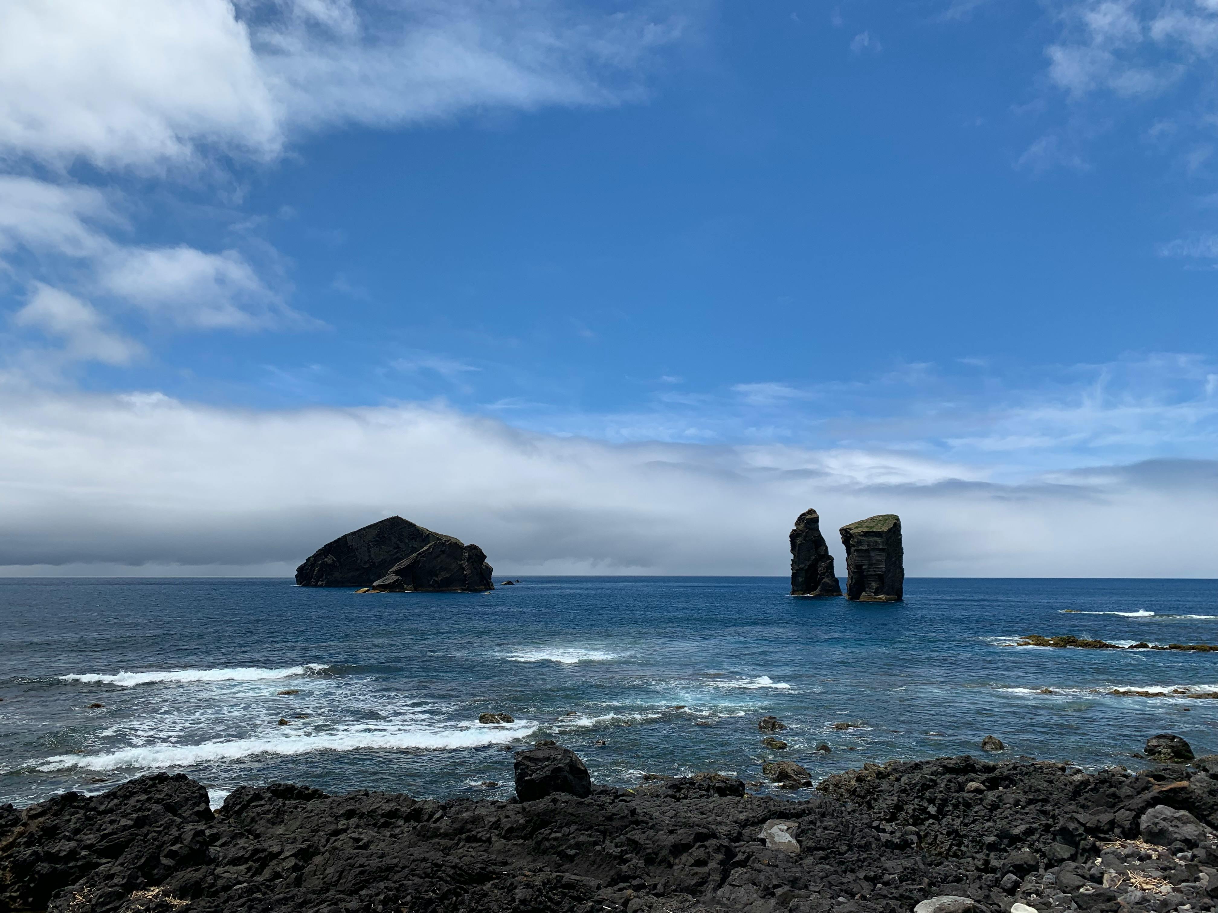Captivating view of rocky islets in the Atlantic under a vibrant blue sky.