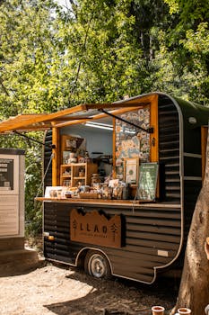 Cozy coffee truck surrounded by lush forest in Río Negro, Argentina, offering a nature retreat.