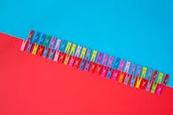 Colorful Clothespins on Red and Blue Background