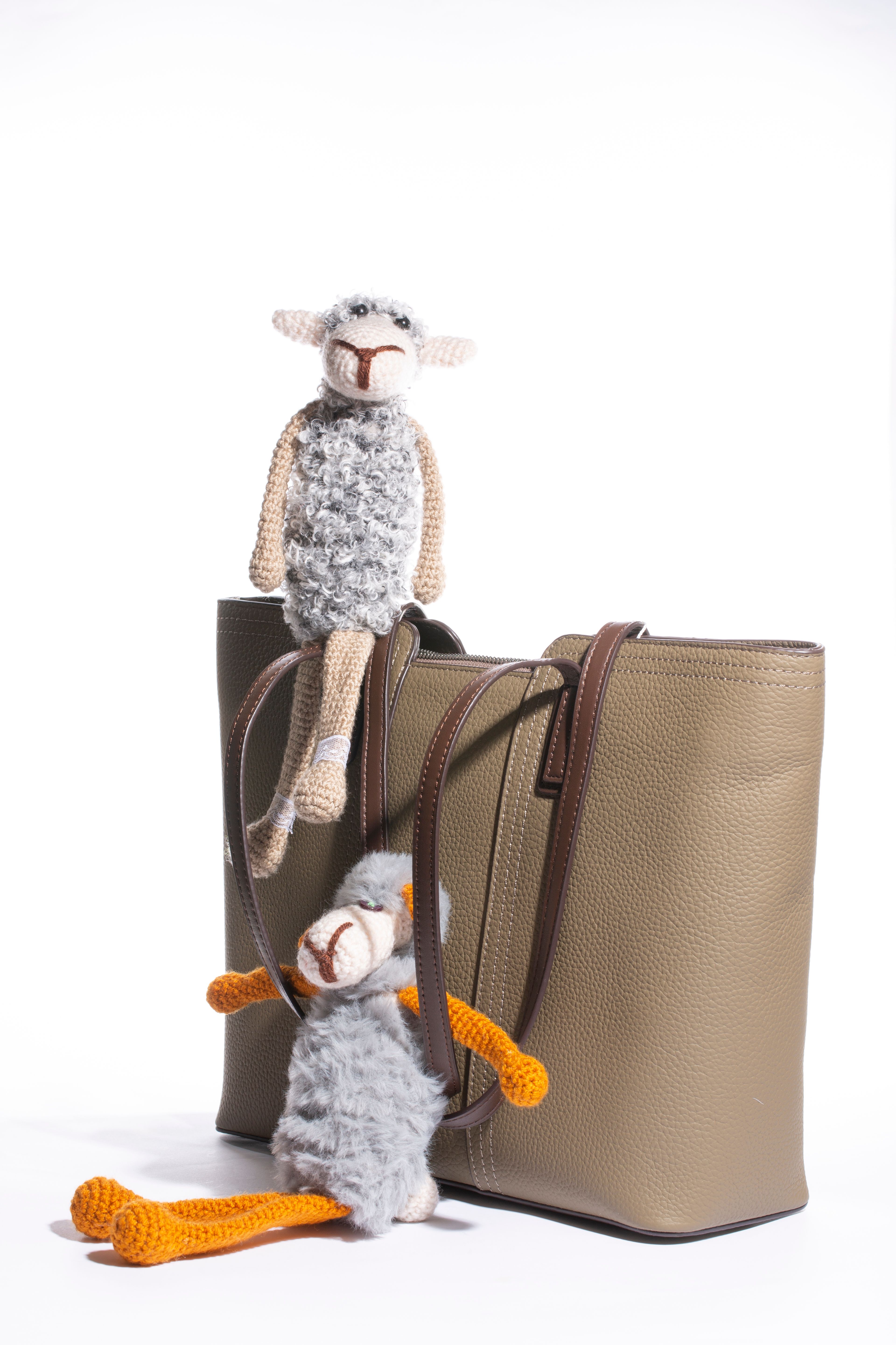 Plush charm toys on a leather tote — photo by Valentin Ivantsov on Pexels