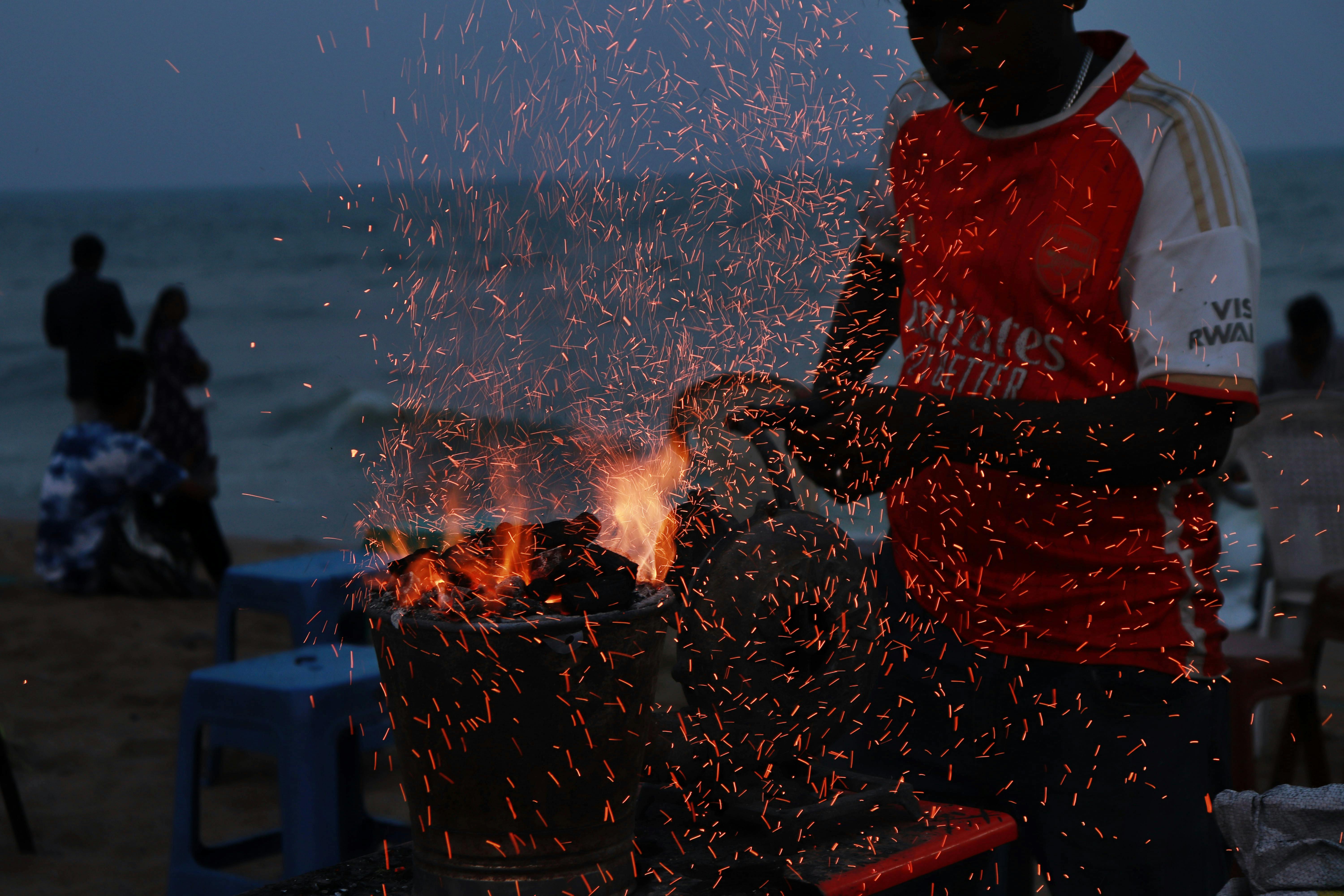 BBQ pit setup at East Coast Park Singapore with charcoal grill and sea view at dusk