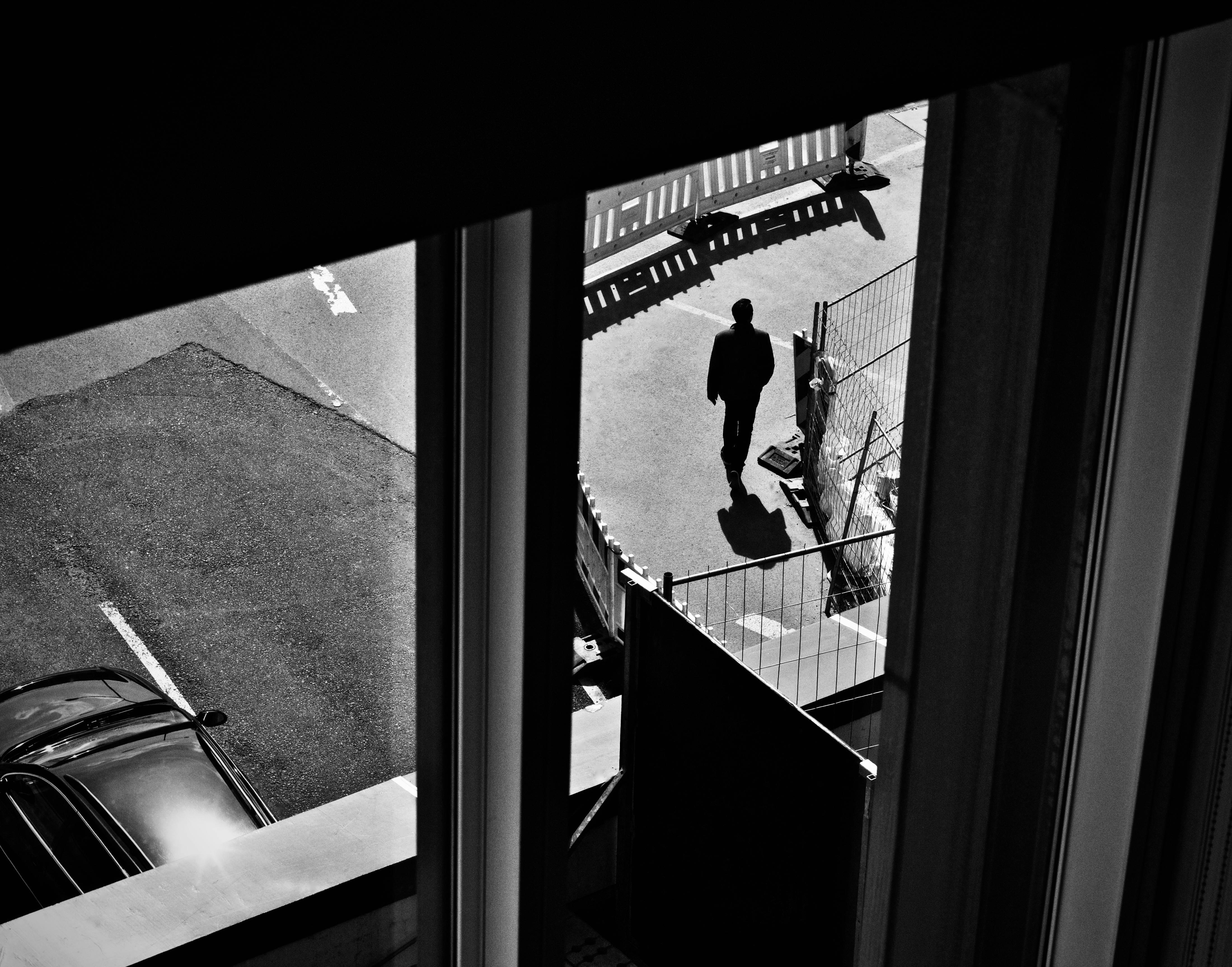 Free A lone silhouette walking on an urban street from a high angle view. Stock Photo