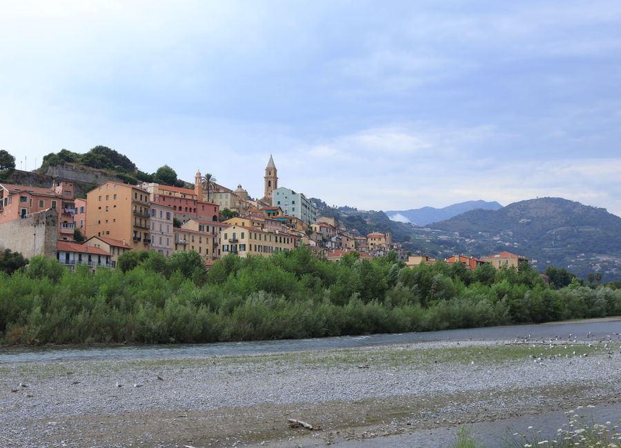 Picturesque hillside town on the Italian Riviera with colorful buildings under a cloudy sky.