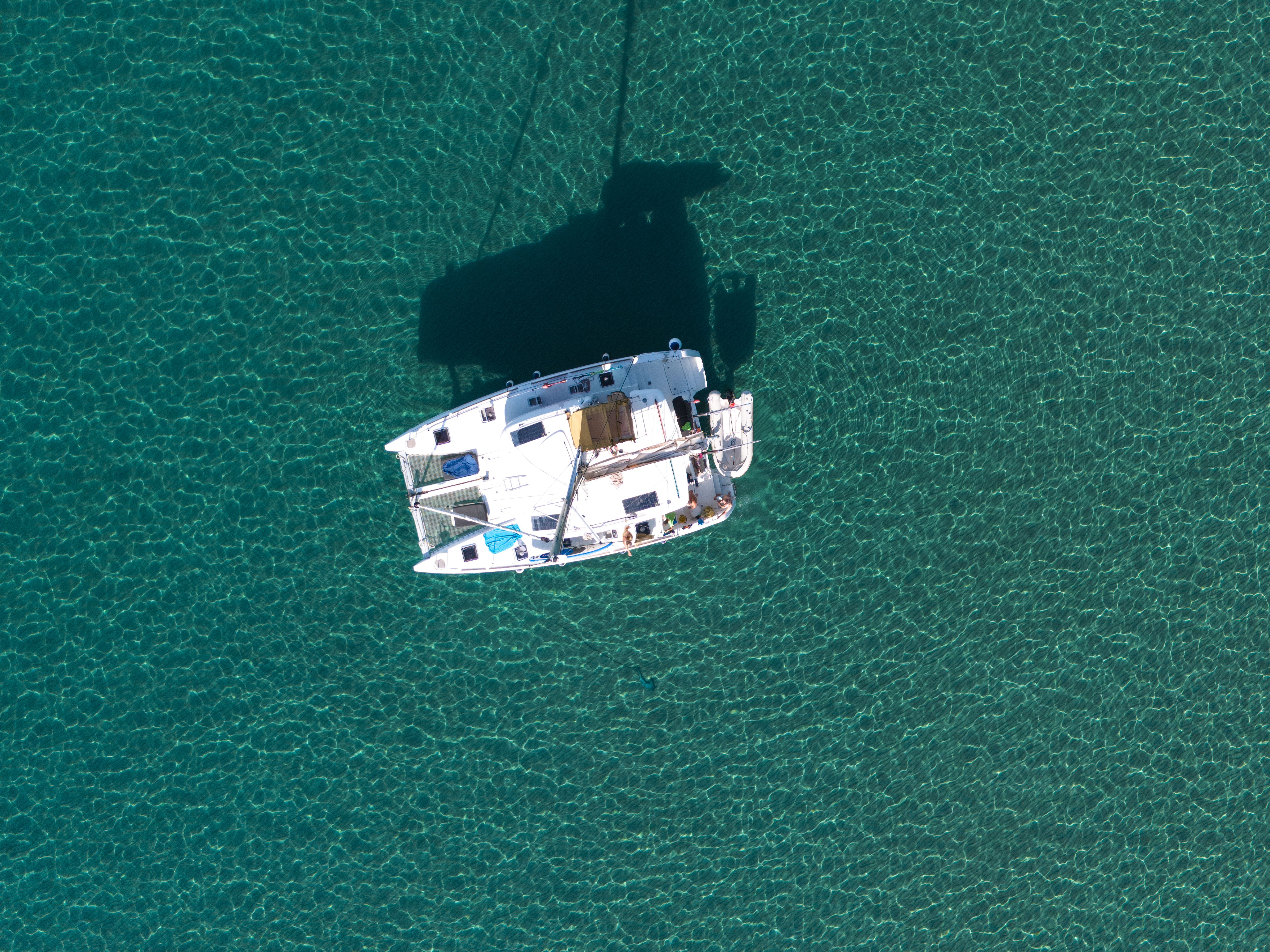 Stunning Cefalù : Mini Yacht Tour with Aperitif, Snorkeling and Caves Review 2026 - Stunning aerial shot of a yacht sailing over clear turquoise waters in Sardinia, Italy.