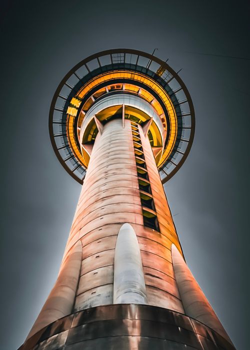 Free Dynamic low angle shot of Auckland's Sky Tower illuminated at night, showcasing modern architectural design. Stock Photo