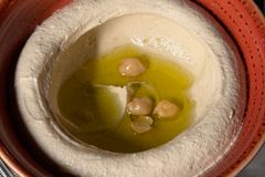 Delicious hummus dip garnished with olive oil and chickpeas.