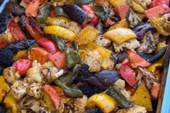 A vibrant tray of assorted roasted vegetables including cauliflower, peppers, and eggplant.