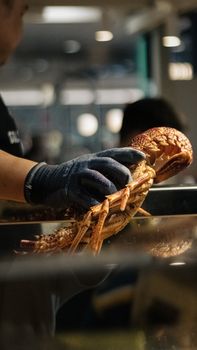 Close-up of chef holding live lobster in a Sydney restaurant, showcasing seafood preparation.