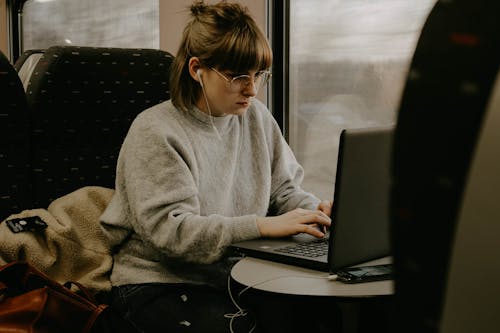 Woman in Gray Sweater Using Laptop Computer