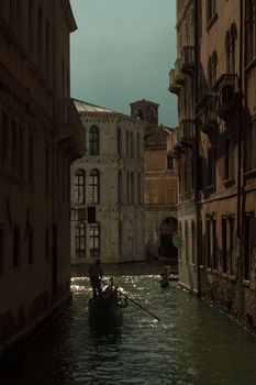 Serene gondola ride through historic canals of Venice at dusk with vintage architectural backdrop.