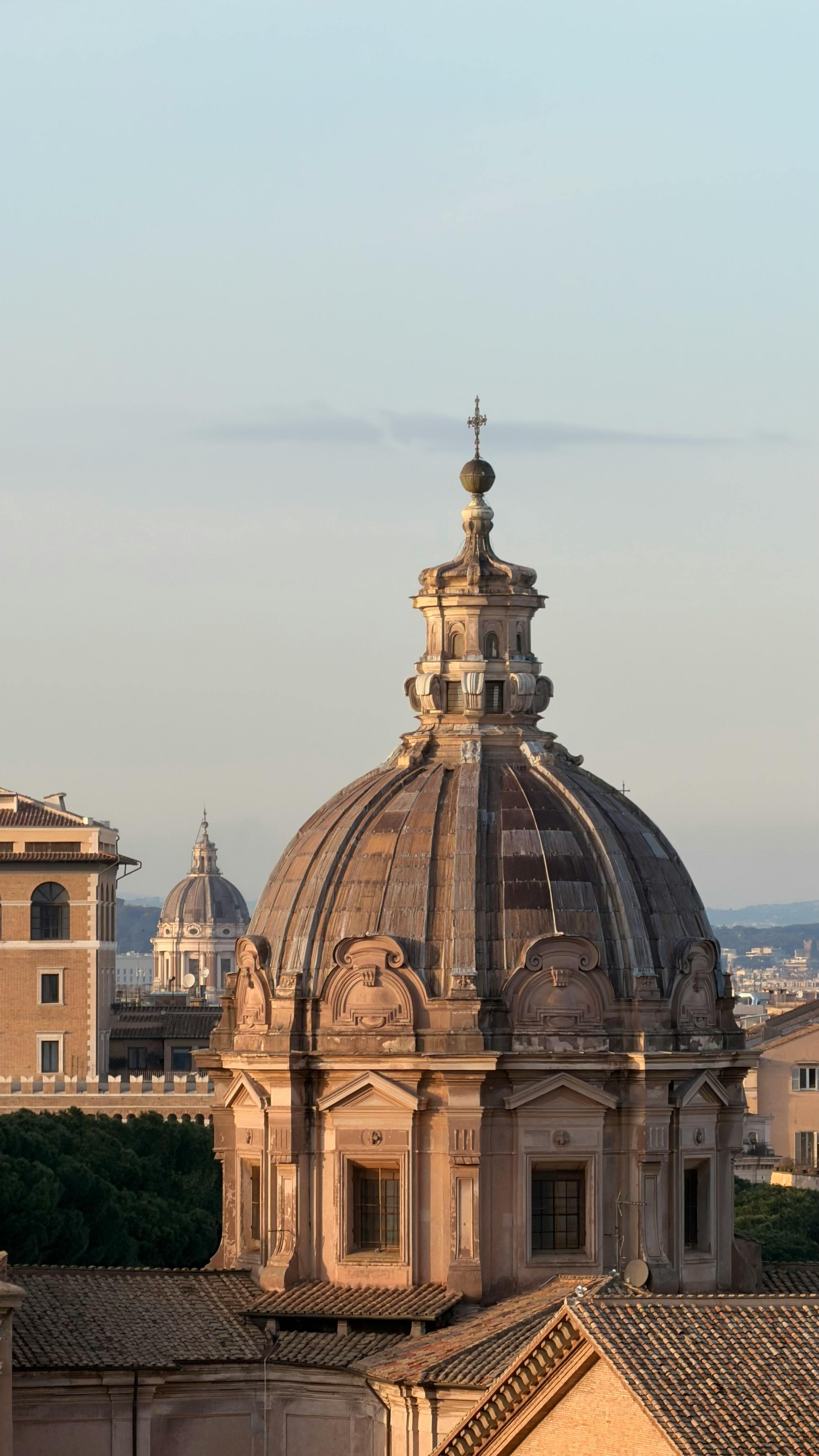 無料 日没時のローマのドームの魅惑的な景色。古典的な建築の美しさと歴史的重要性を示しています。 写真素材